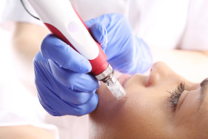 Beautician performs a needle mesotherapy treatment on a woman's face